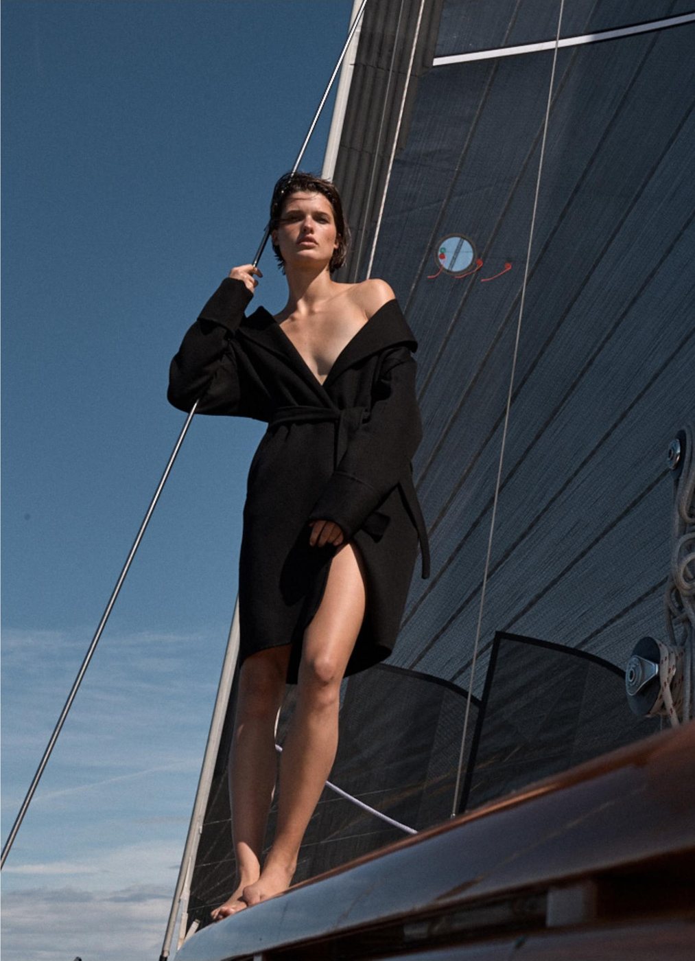 A figure on deck under sail, headsail drawing behind